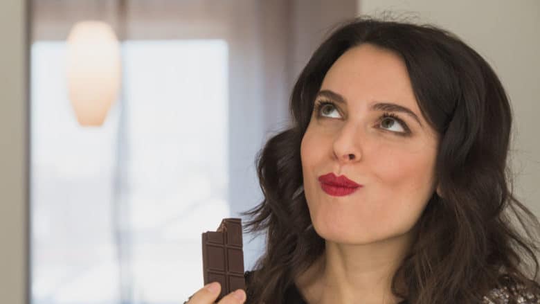 Woman eating chocolate at home